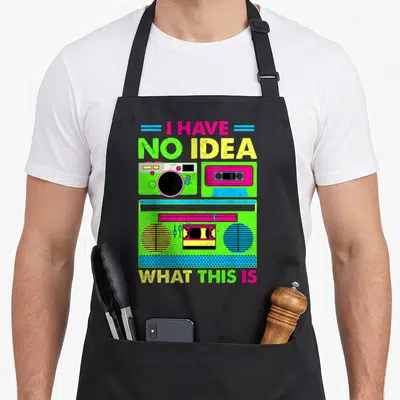 Funny 80s chef outfit with apron - Neon green pink and yellow boombox graphic with text I HAVE NO IDEA WHAT THIS IS — shown on a black cotton canvas apron against a white background