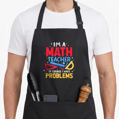 Problem mathematic teacher apron - Stacked text I'M A MATH TEACHER OF COURSE I HAVE PROBLEMS with red ruler, blue — shown on a black cotton canvas apron against a white background