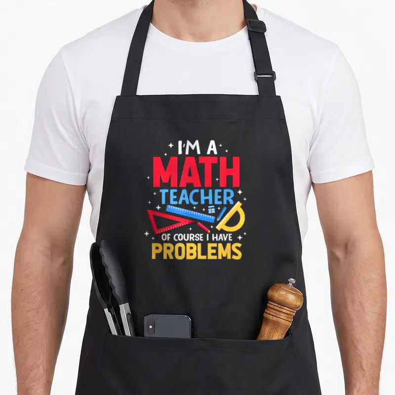 Problem mathematic teacher apron - Stacked text I'M A MATH TEACHER OF COURSE I HAVE PROBLEMS with red ruler, blue — shown on a black cotton canvas apron against a white background