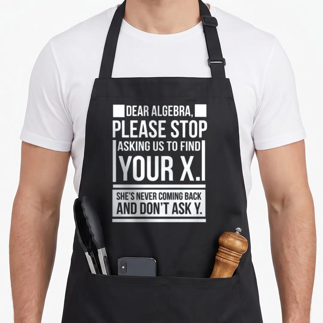 Dear nerd apron - White stacked text on black background reading Dear Algebra please stop asking us to find your x — shown on a black cotton canvas apron against a white background