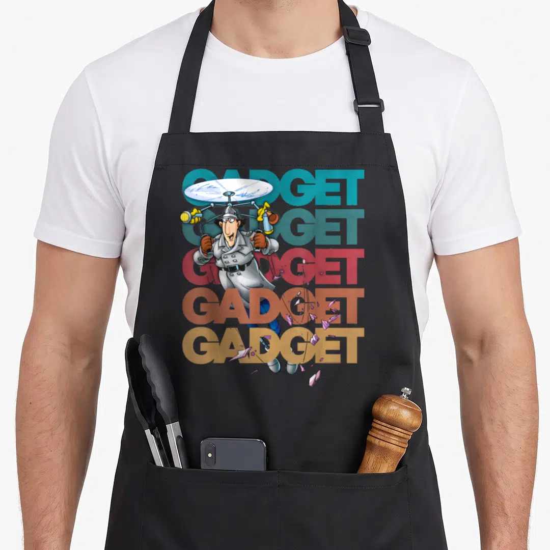 Inspector gadget apron - Cartoon spy with helicopter hat over five stacked GADGET words in teal red brown tan grey — shown on a black cotton canvas apron against a white background
