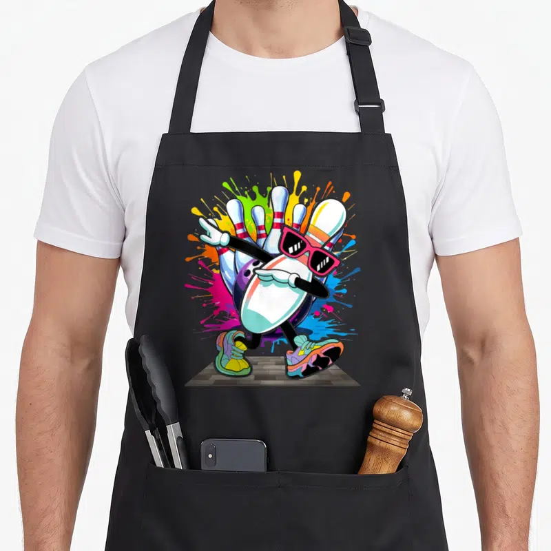 Sunglass pins for aprons - Dabbing bowling pin with pink sunglasses and sneakers amidst blue pink yellow paint splashes — shown on a black cotton canvas apron against a white background
