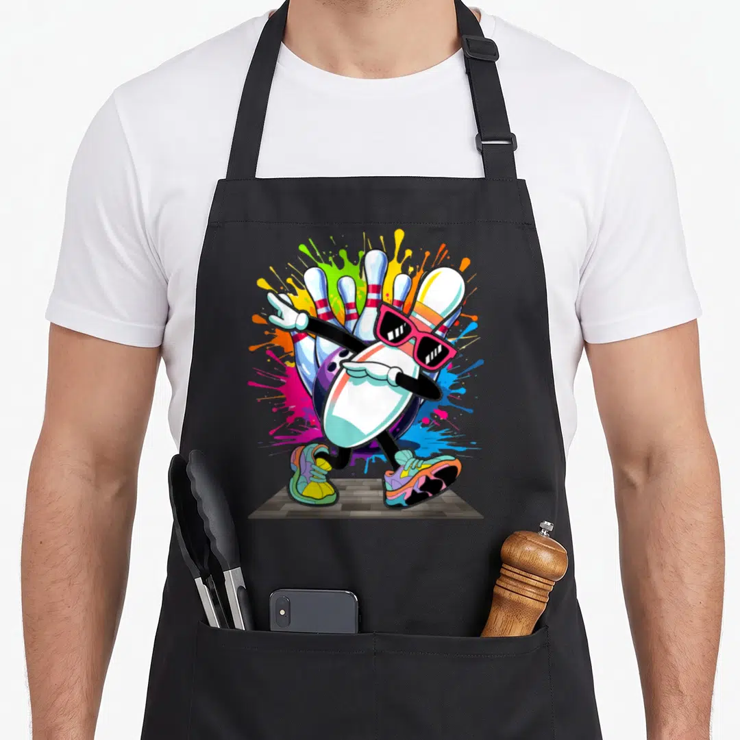 Sunglass pins for aprons - Dabbing bowling pin with pink sunglasses and sneakers amidst blue pink yellow paint splashes — shown on a black cotton canvas apron against a white background