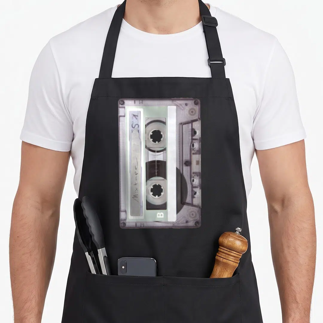 School hip aprons - Purple cassette tape with handwritten S 1 Mixtape B label — shown on a black cotton canvas apron against a white background