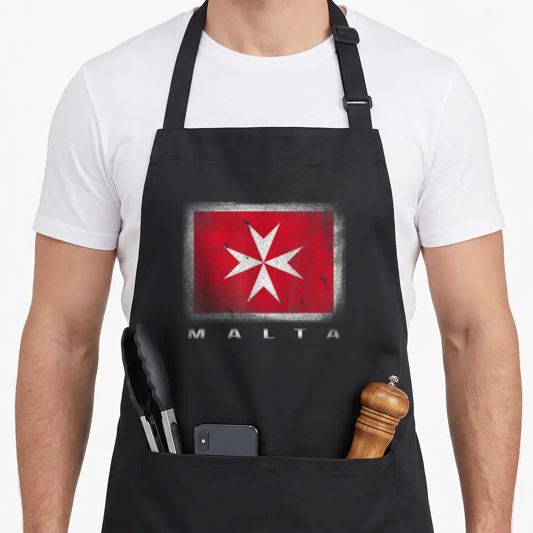 Maltese cross apron - Distressed red flag with white cross and MALTA text below — shown on a black cotton canvas apron against a white background