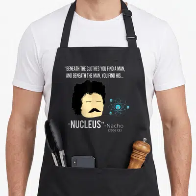 Perfect wrestling apron - Nacho face with atom model and quote beneath the clothes you find a man nucleus — shown on a black cotton canvas apron against a white background