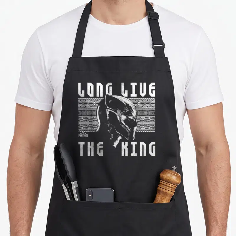 Live urban apron - Distressed Black Panther head over tribal pattern with Long Live The King text — shown on a black cotton canvas apron against a white background