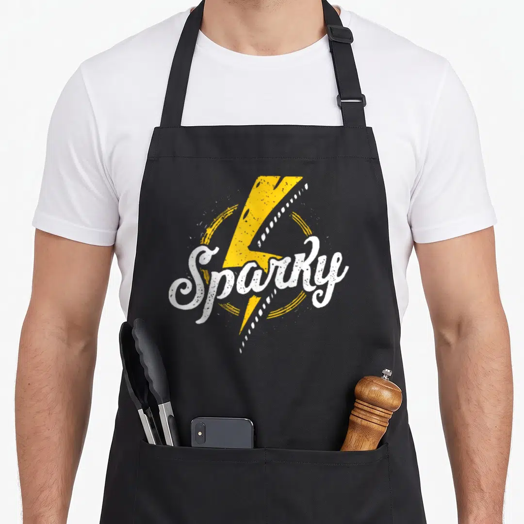 Retro sparky electricians apron - Yellow lightning bolt behind white distressed text reading Sparky on black fabric — shown on a black cotton canvas apron against a white background
