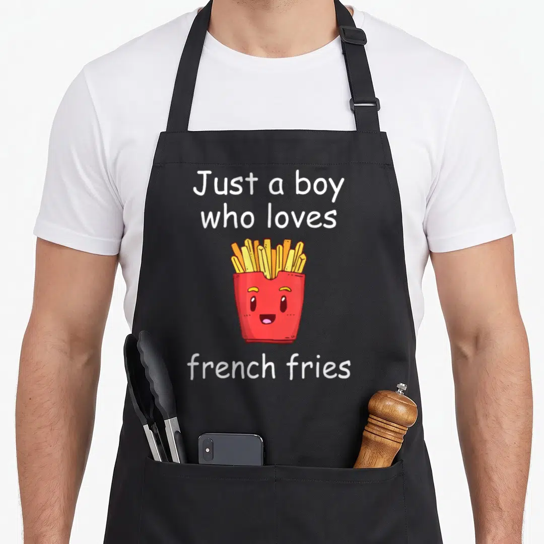 Funny fry french apron - Smiling red french fry container with yellow fries and white text — shown on a black cotton canvas apron against a white background