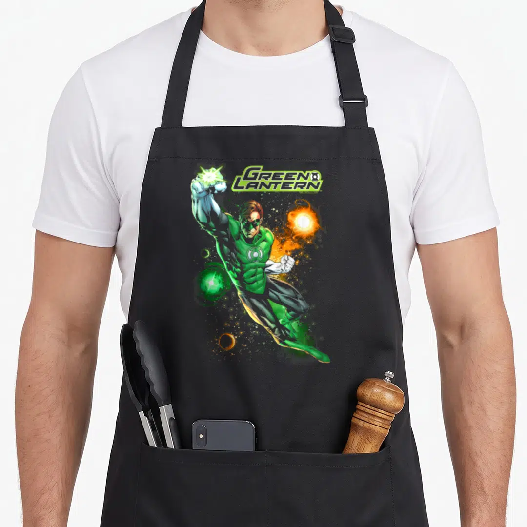 Lantern comics apron - Green Lantern text with hero in green suit firing green blast and orange sphere — shown on a black cotton canvas apron against a white background