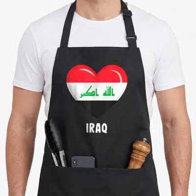 Iraq iraqi apron - Heart shape with Iraqi flag colors and green Arabic script above white IRAQ text — shown on a black cotton canvas apron against a white background