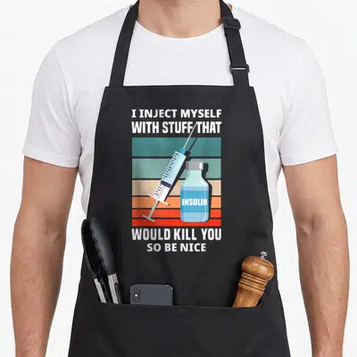 Diabetic novelty apron - Syringe and insulin vial over teal orange red stripes with white text — shown on a black cotton canvas apron against a white background
