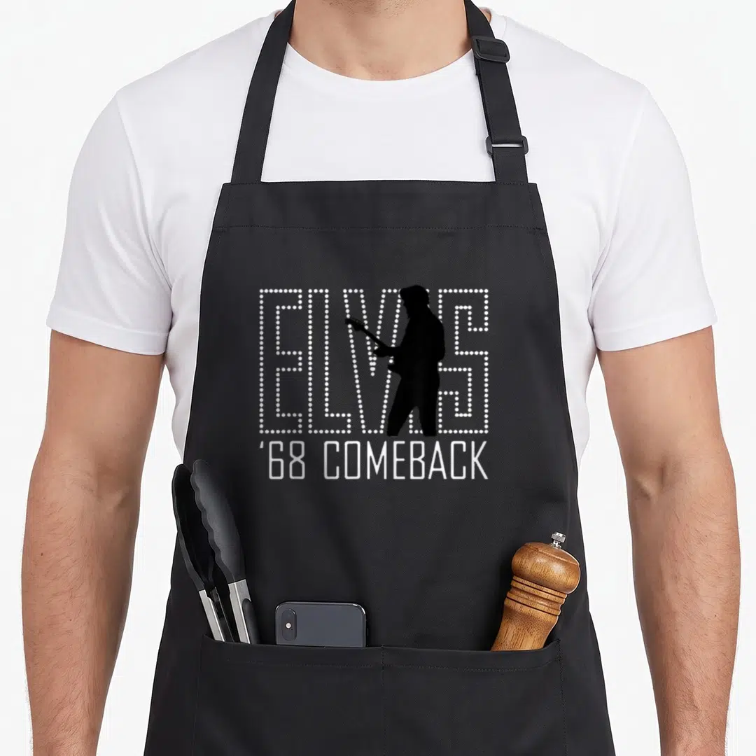 Presley comeback apron - White dotted ELVIS text with guitar player silhouette and ''68 COMEBACK below — shown on a black cotton canvas apron against a white background