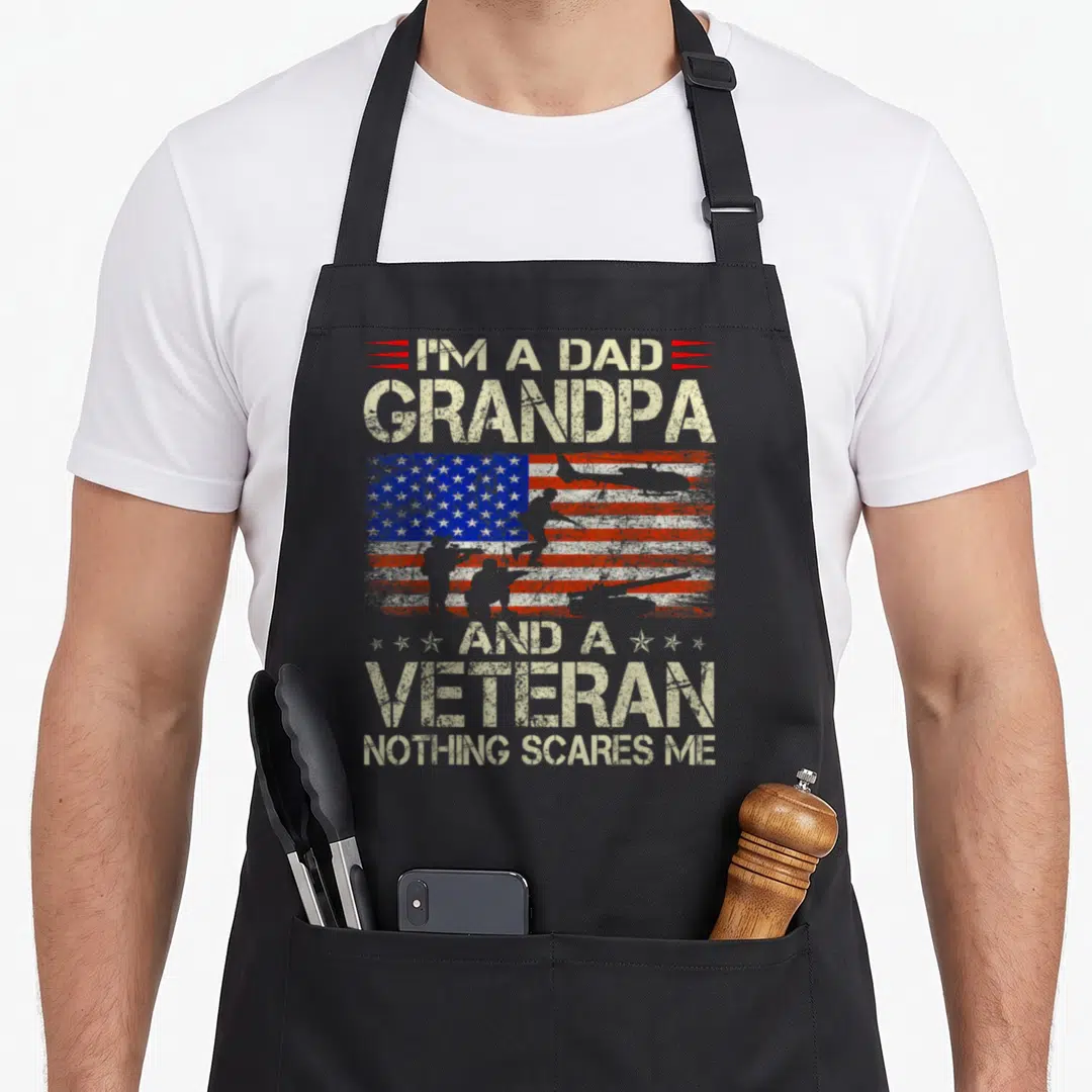 Veteran papa grandpa apron - Distressed USA flag with soldier silhouettes and stacked text reading I'm a Dad Grandpa — shown on a black cotton canvas apron against a white background