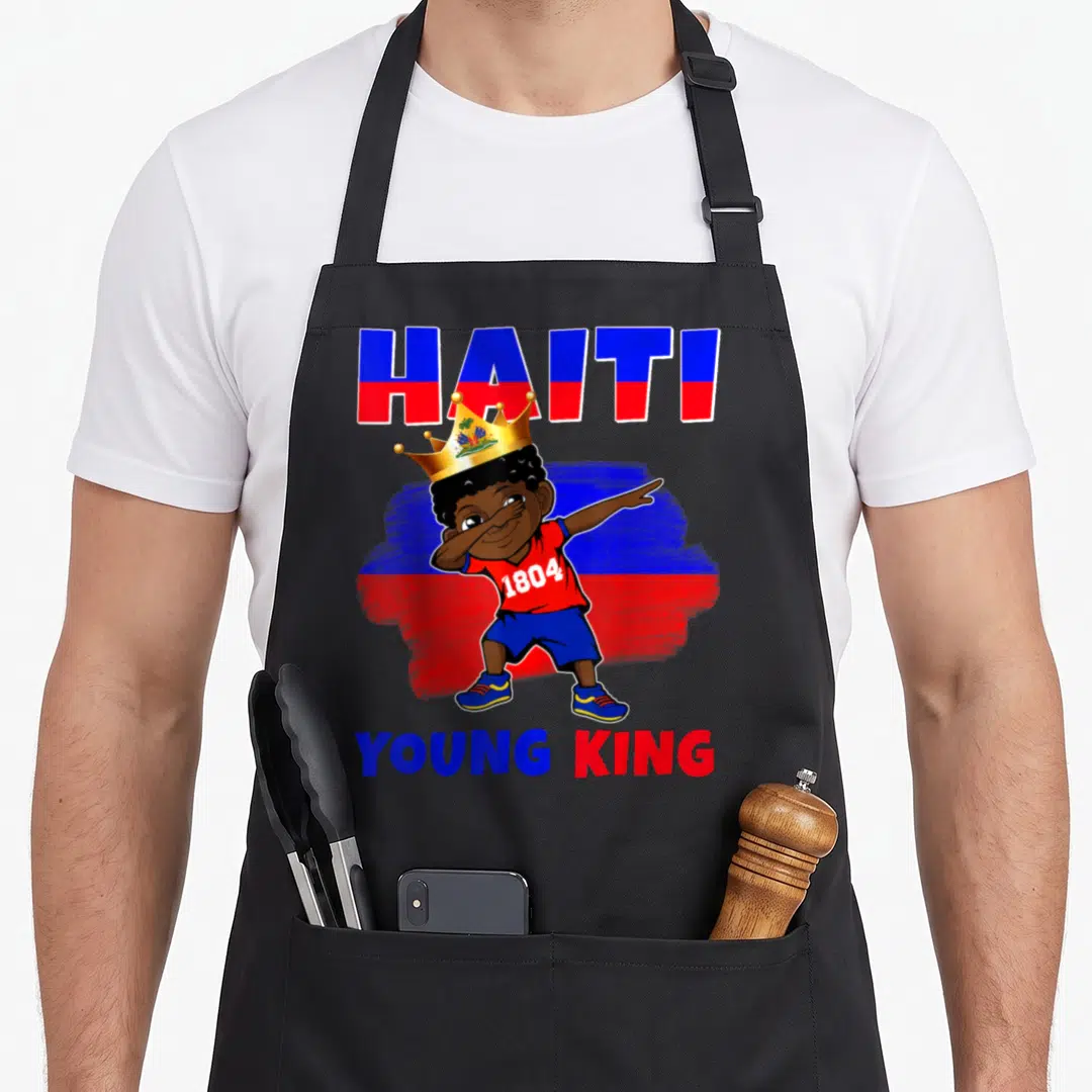 Haiti king apron - Cartoon boy dabbing in gold crown with Haiti 1804 Young King text over blue red flag strokes — shown on a black cotton canvas apron against a white background