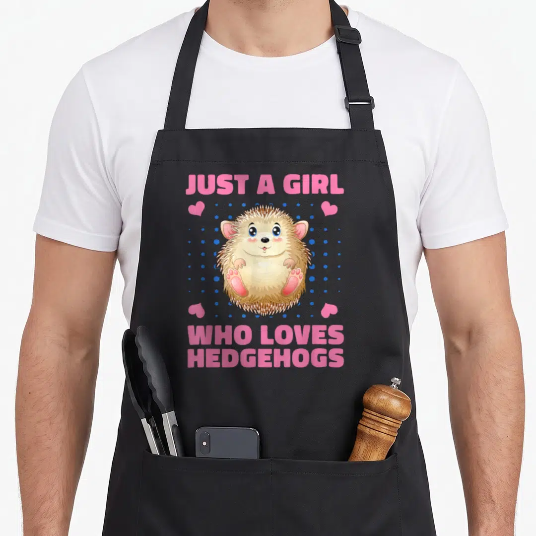 Funny hedgehog pet apron - Cartoon hedgehog with pink text and blue dots on black apron — shown on a black cotton canvas apron against a white background