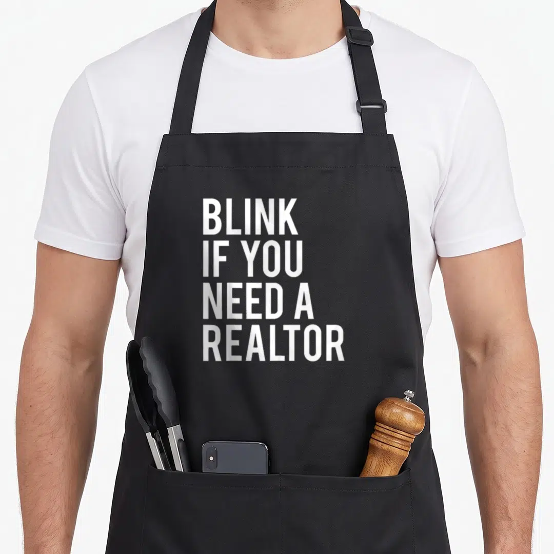 Agent realtor apron - White stacked text BLINK IF YOU NEED A REALTOR on grey background — shown on a black cotton canvas apron against a white background