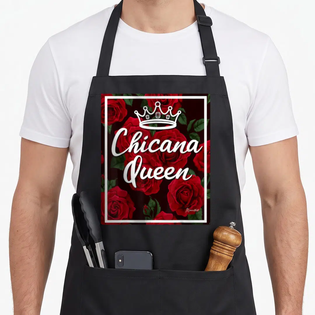Chicana rose apron - White crown and script over red roses enclosed in a white border — shown on a black cotton canvas apron against a white background