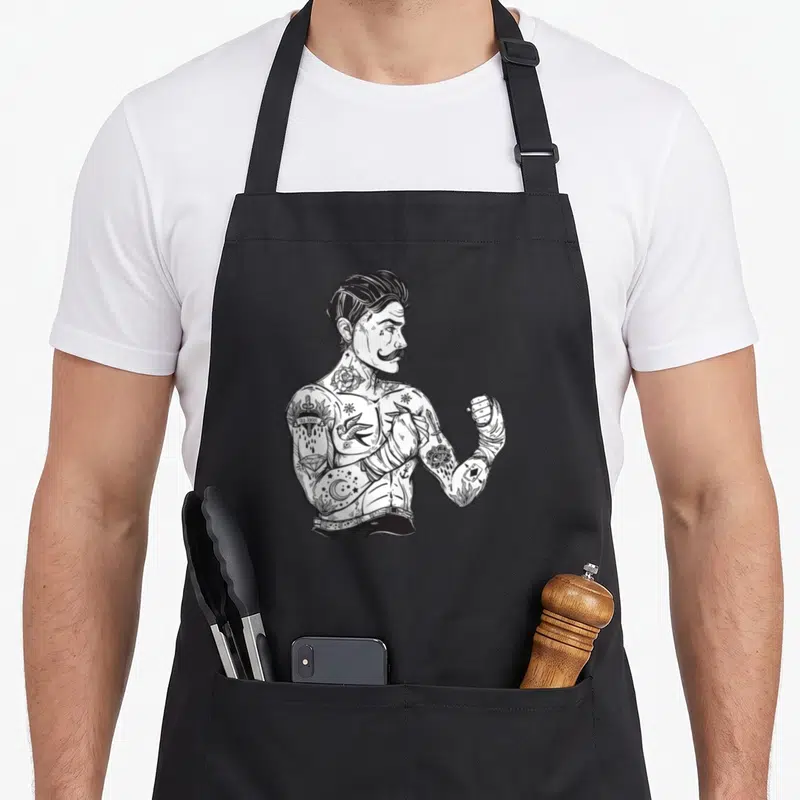 Boxing boho apron - Tattooed boxer facing right with OLD SCHOOL arm ink and hand wraps in black and white line art — shown on a black cotton canvas apron against a white background