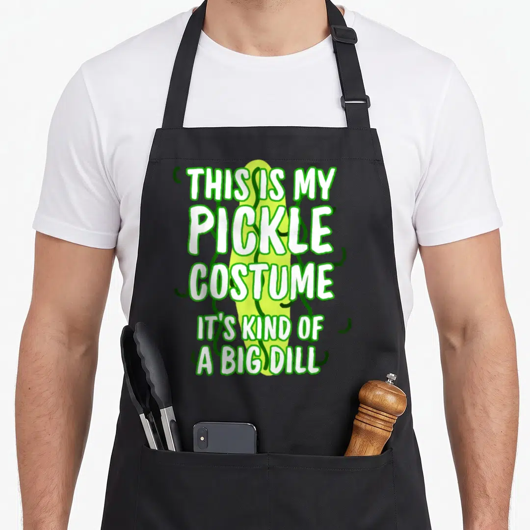 Pickle costume halloween apron - Stacked white text over a lime green pickle with dark green curlicues — shown on a black cotton canvas apron against a white background