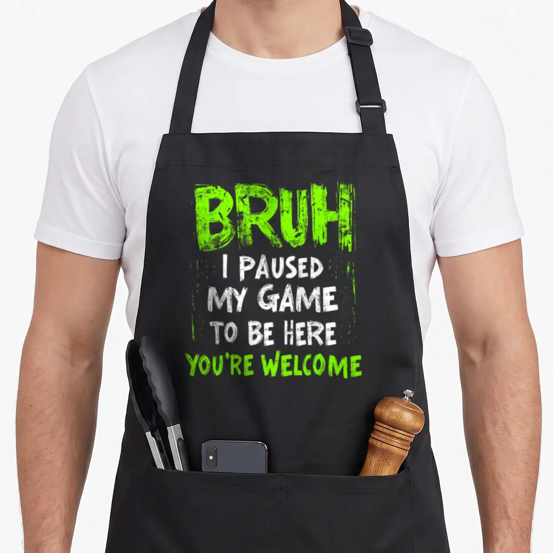Gamer bruh video game apron - Five line distressed text BRUH I PAUSED MY GAME TO BE HERE YOU'RE WELCOME in lime — shown on a black cotton canvas apron against a white background