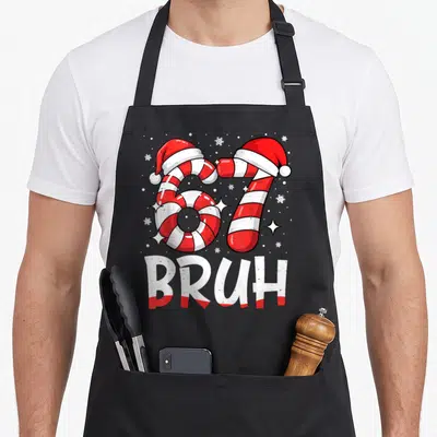 Bruh candy cane apron - Number 67 formed by red and white candy canes with Santa hats and BRUH text — shown on a black cotton canvas apron against a white background