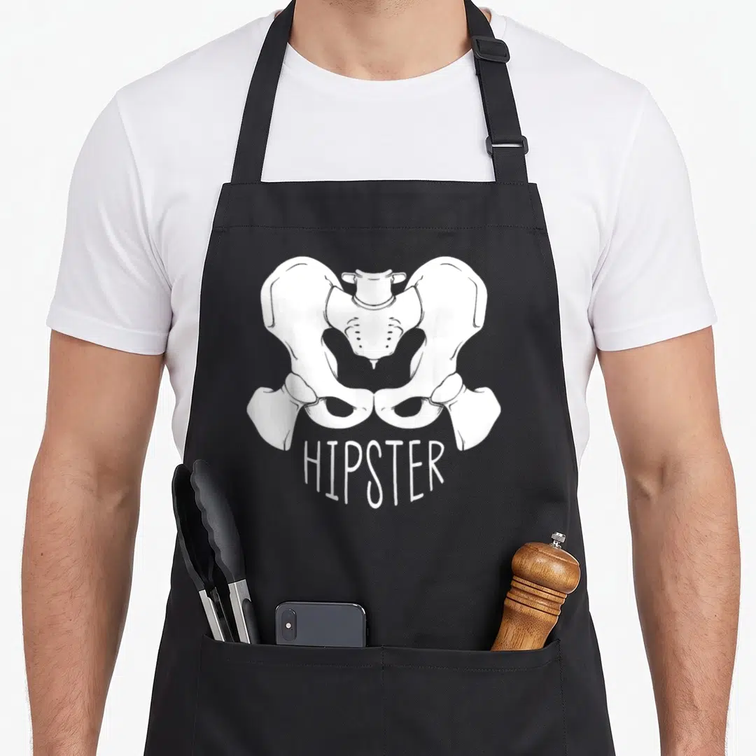 Orthopaedic surgeon apron - White line drawing of a human pelvis positioned above the text HIPSTER in minimalist style — shown on a black cotton canvas apron against a white background