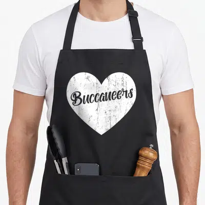 Mascot heart-shaped apron - Distressed white heart with grey Buccaneers script text centered on the design — shown on a black cotton canvas apron against a white background