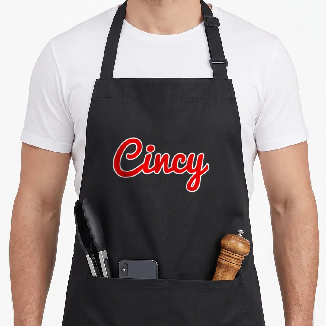 Ohio cincinnati apron - Red script Cincy text with white outline on grey background — shown on a black cotton canvas apron against a white background