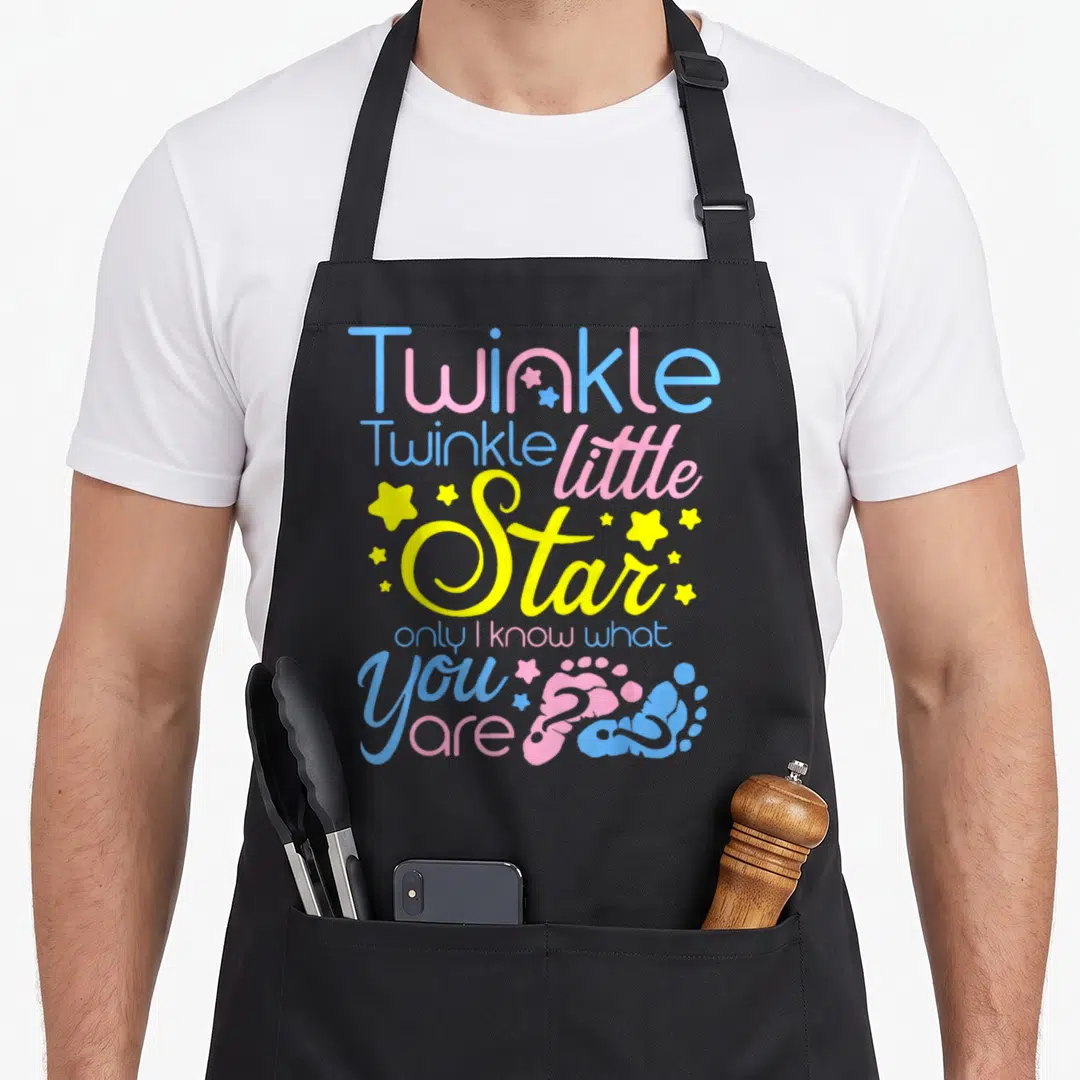 Twinkle honestly apron - Stacked text Twinkle Twinkle little Star with blue pink yellow colors and two baby footprints — shown on a black cotton canvas apron against a white background