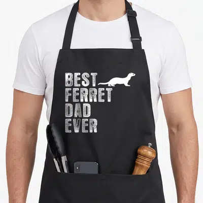 Funny ferret pet apron - White distressed text BEST FERRET DAD EVER with ferret silhouette — shown on a black cotton canvas apron against a white background