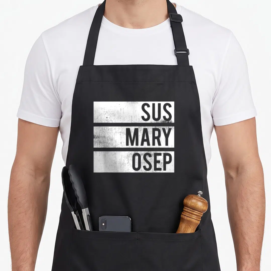 Mary distressed apron - Stacked grey text SUS MARY OSEP inside white distressed rectangles on black fabric — shown on a black cotton canvas apron against a white background