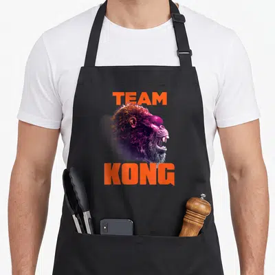 Neon hong kong apron - Kong head in orange purple black with TEAM above and KONG below text — shown on a black cotton canvas apron against a white background