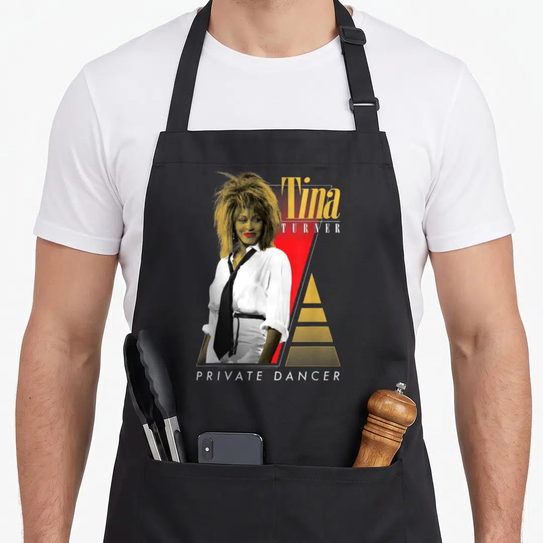 Tina concert lover apron - Retro graphic of Tina Turner overlapping red triangle with PRIVATE DANCER text in yellow — shown on a black cotton canvas apron against a white background
