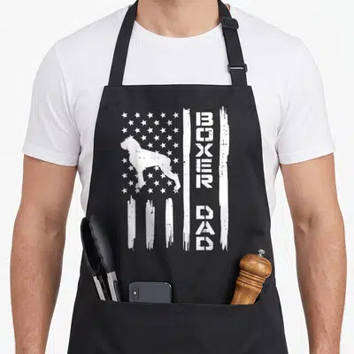 Flag patriotic boxer dog apron - White boxer dog silhouette on distressed flag with vertical BOXER DAD text — shown on a black cotton canvas apron against a white background