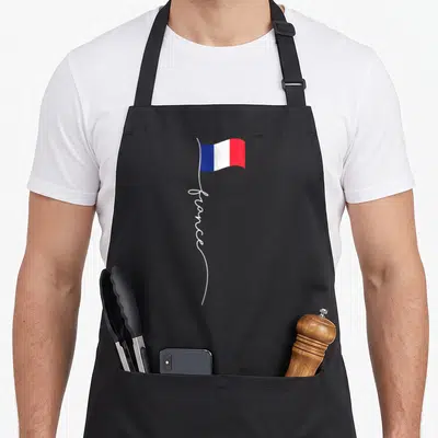 Signature french apron - France flag with pole forming script text in blue white and red — shown on a black cotton canvas apron against a white background