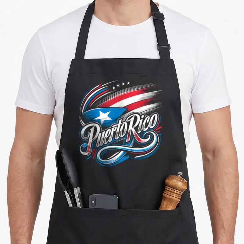 Rico heritage aprons - Stylized Puerto Rico flag text in red white blue brushstrokes with four stars — shown on a black cotton canvas apron against a white background