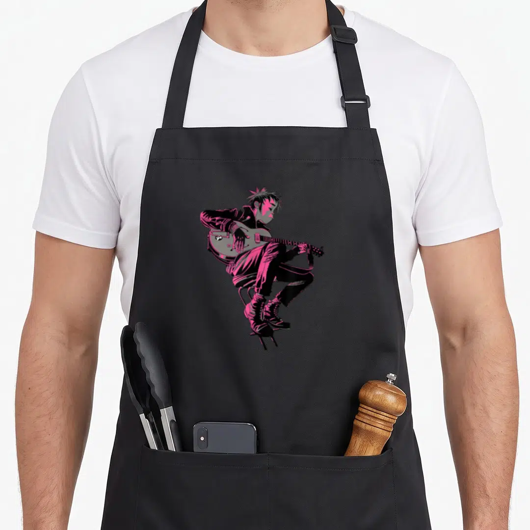 Gorillaz character aprons - Black and pink cartoon person sitting on a chair playing an electric guitar — shown on a black cotton canvas apron against a white background