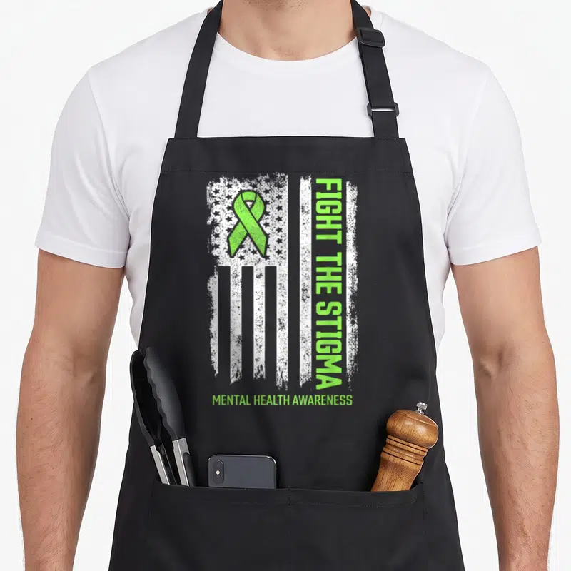 Fight mental health awareness apron - Distressed white flag with lime green ribbon and vertical Fight The Stigma text — shown on a black cotton canvas apron against a white background