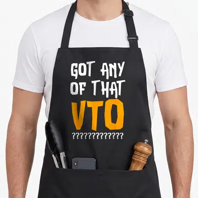 Employee warehouse apron - White and orange stacked text reading GOT ANY OF THAT VTO with twelve question marks below — shown on a black cotton canvas apron against a white background