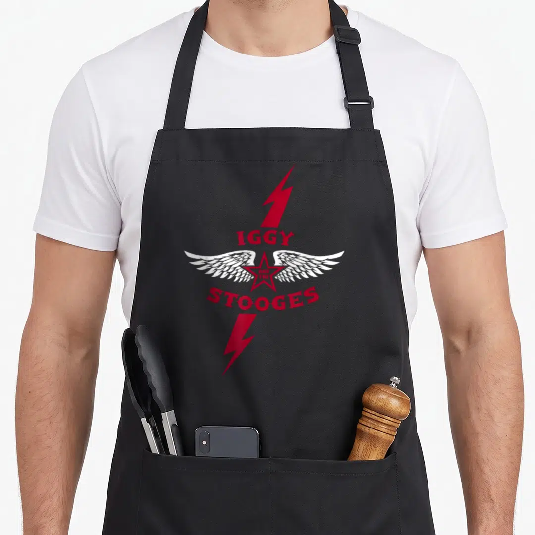 Iggy pop apron - Red star with white wings and two lightning bolts surrounding red text IGGY AND THE STOOGES — shown on a black cotton canvas apron against a white background