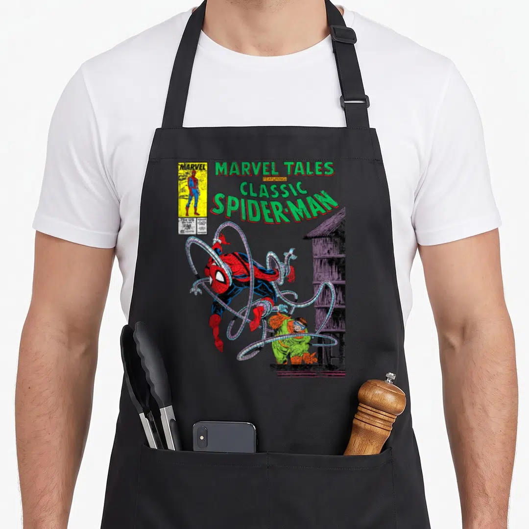 Octopus doctor apron - Vintage comic cover print showing Spider-Man in red and blue fighting near a building with green — shown on a black cotton canvas apron against a white background