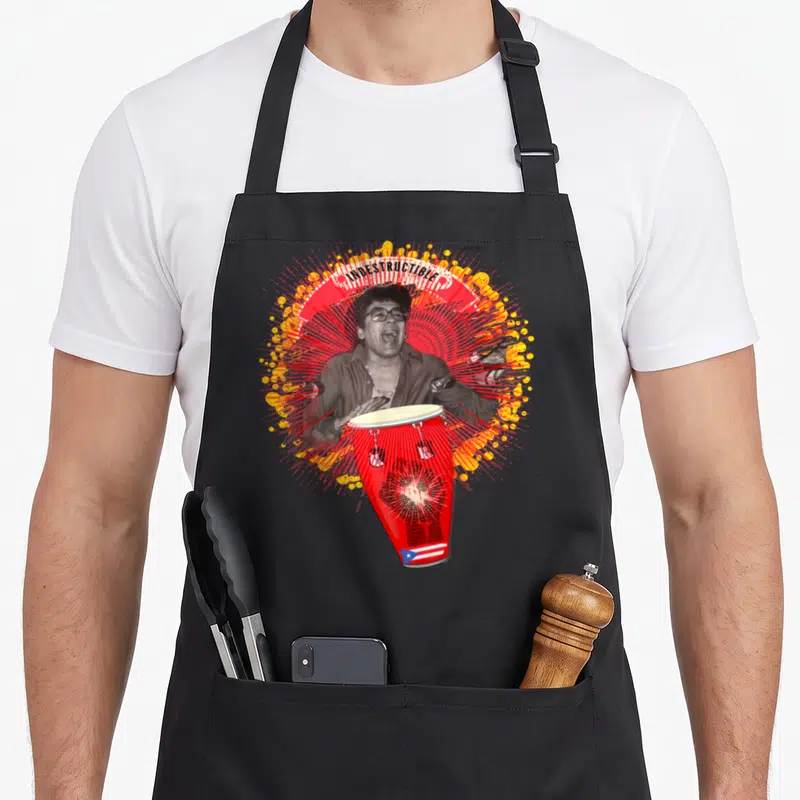 Puertorico crew apron - Indestructible text over man playing red conga drum with Puerto Rico flag and red yellow — shown on a black cotton canvas apron against a white background