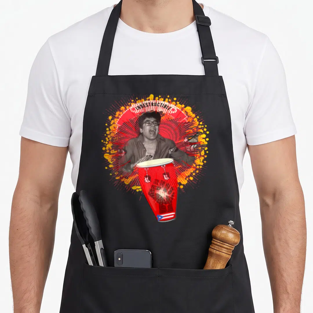 Puertorico crew apron - Indestructible text over man playing red conga drum with Puerto Rico flag and red yellow — shown on a black cotton canvas apron against a white background