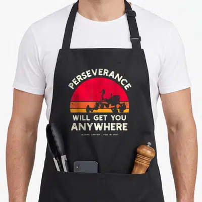 Rover mars apron - Retro sunburst with grey rover silhouette and Perseverance Will Get You Anywhere text — shown on a black cotton canvas apron against a white background