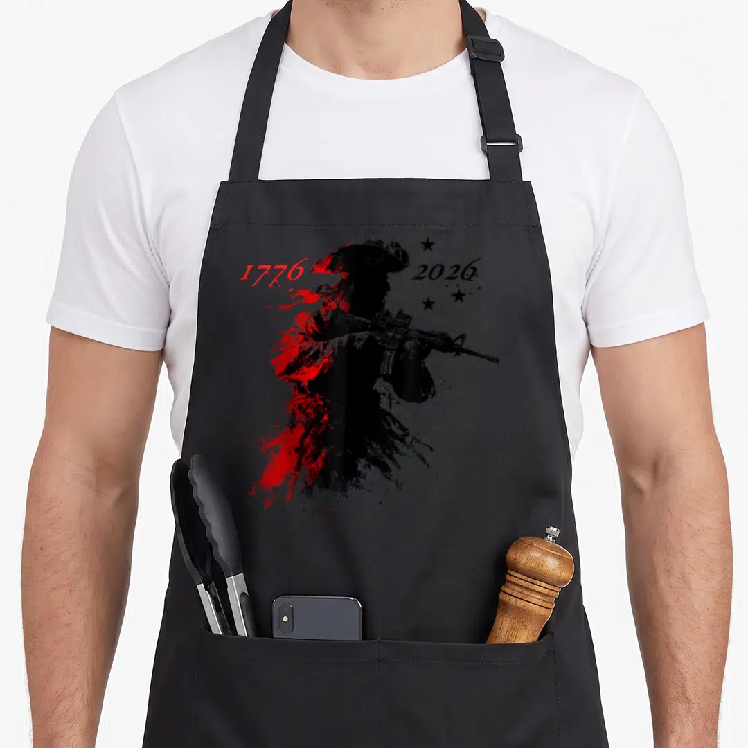 Patriotic yankees apron - Distressed soldier silhouette with rifle, red splatter, and years 1776 and 2026 — shown on a black cotton canvas apron against a white background