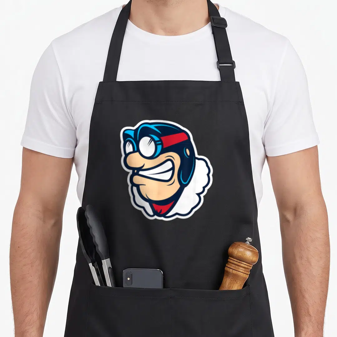 Rudy dayton apron - Cartoon aviator head with goggles, helmet, and white scarf in blue, red, and peach — shown on a black cotton canvas apron against a white background