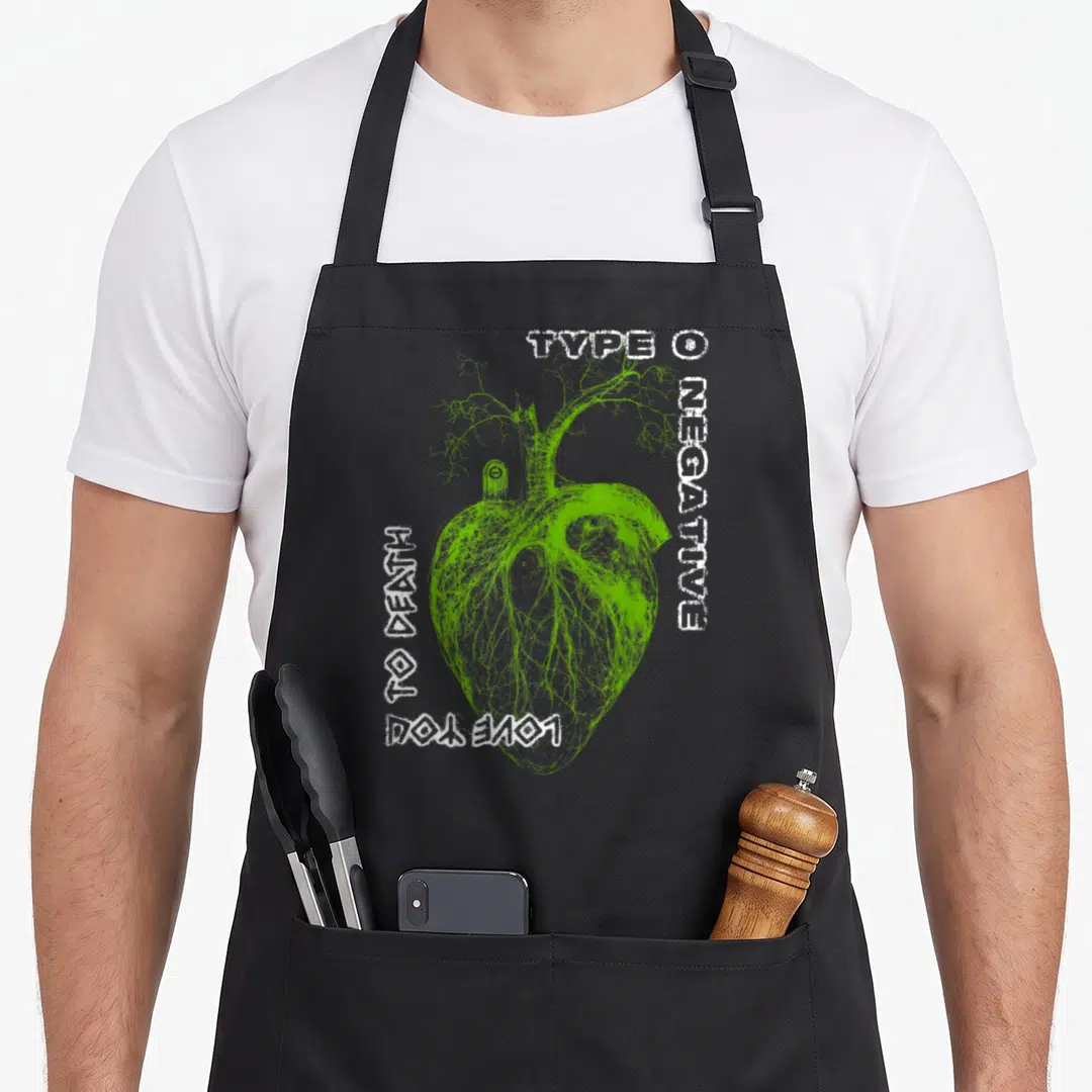 Negative gothic apron - Green anatomical heart with branches and vertical white text on grey background — shown on a black cotton canvas apron against a white background