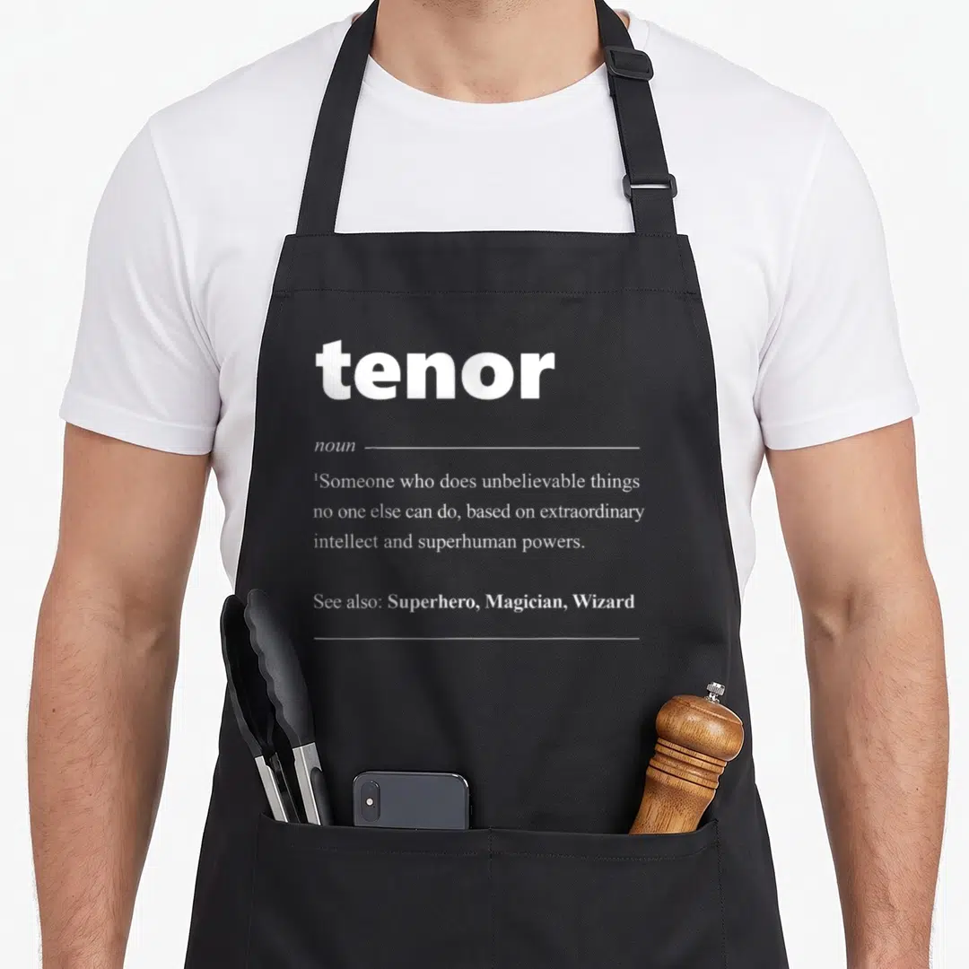 Tenor opera apron - White dictionary definition of tenor as a superhero with superhuman powers on black background — shown on a black cotton canvas apron against a white background