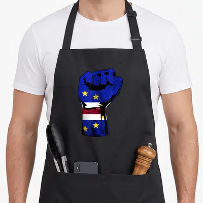 Power pride apron - Raised fist filled with blue red white yellow stars and stripes in distressed style — shown on a black cotton canvas apron against a white background